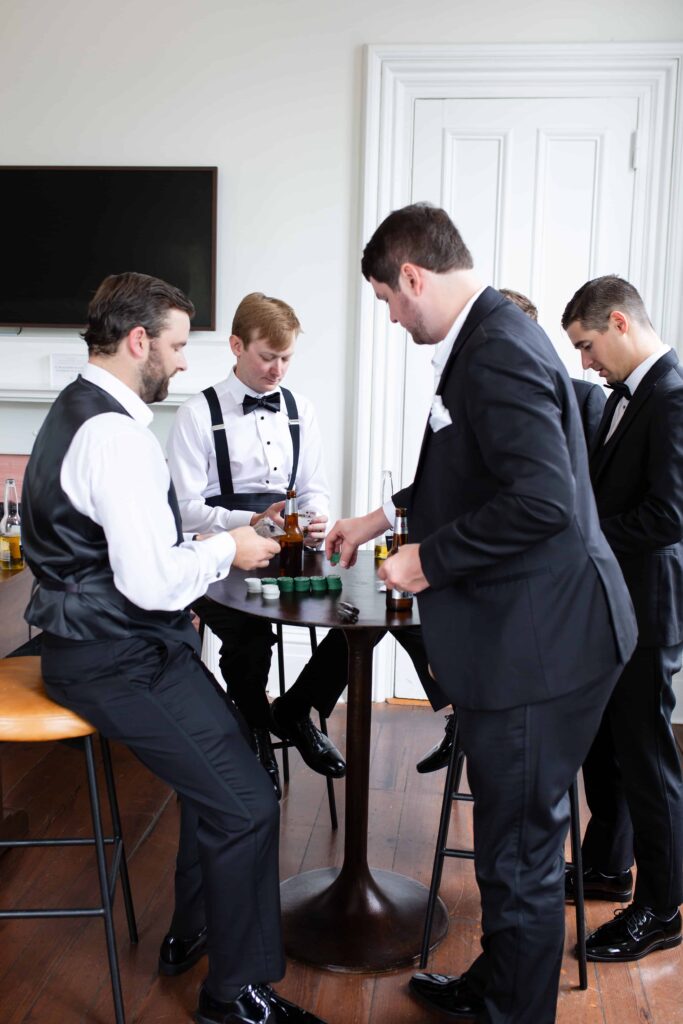 groomsmen playing cards during getting ready captured by raleigh wedding photographer