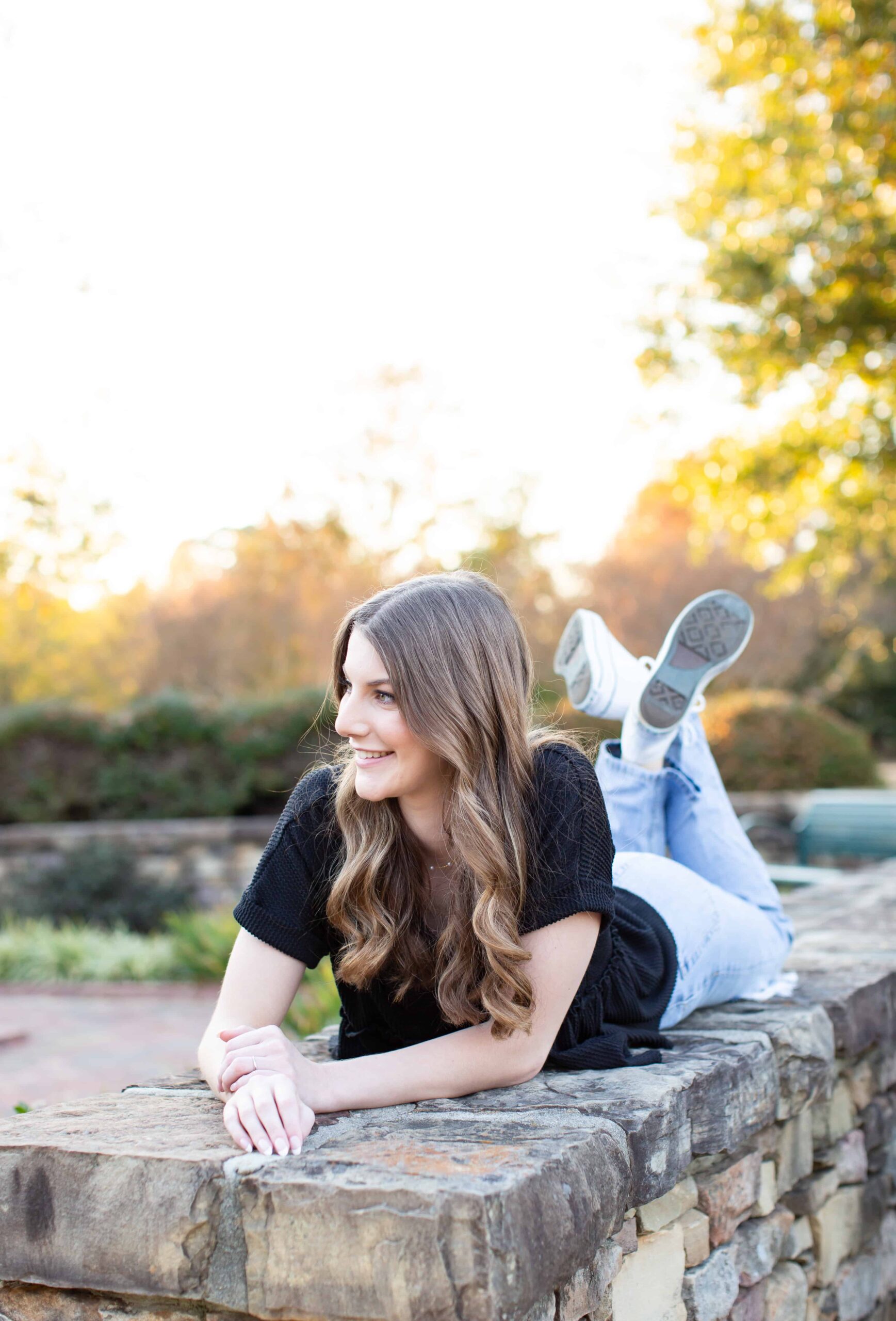 High School Senior girl posing for a photo, wearing black top and jeans. Senior portrait photographer Wake Forest, NC.