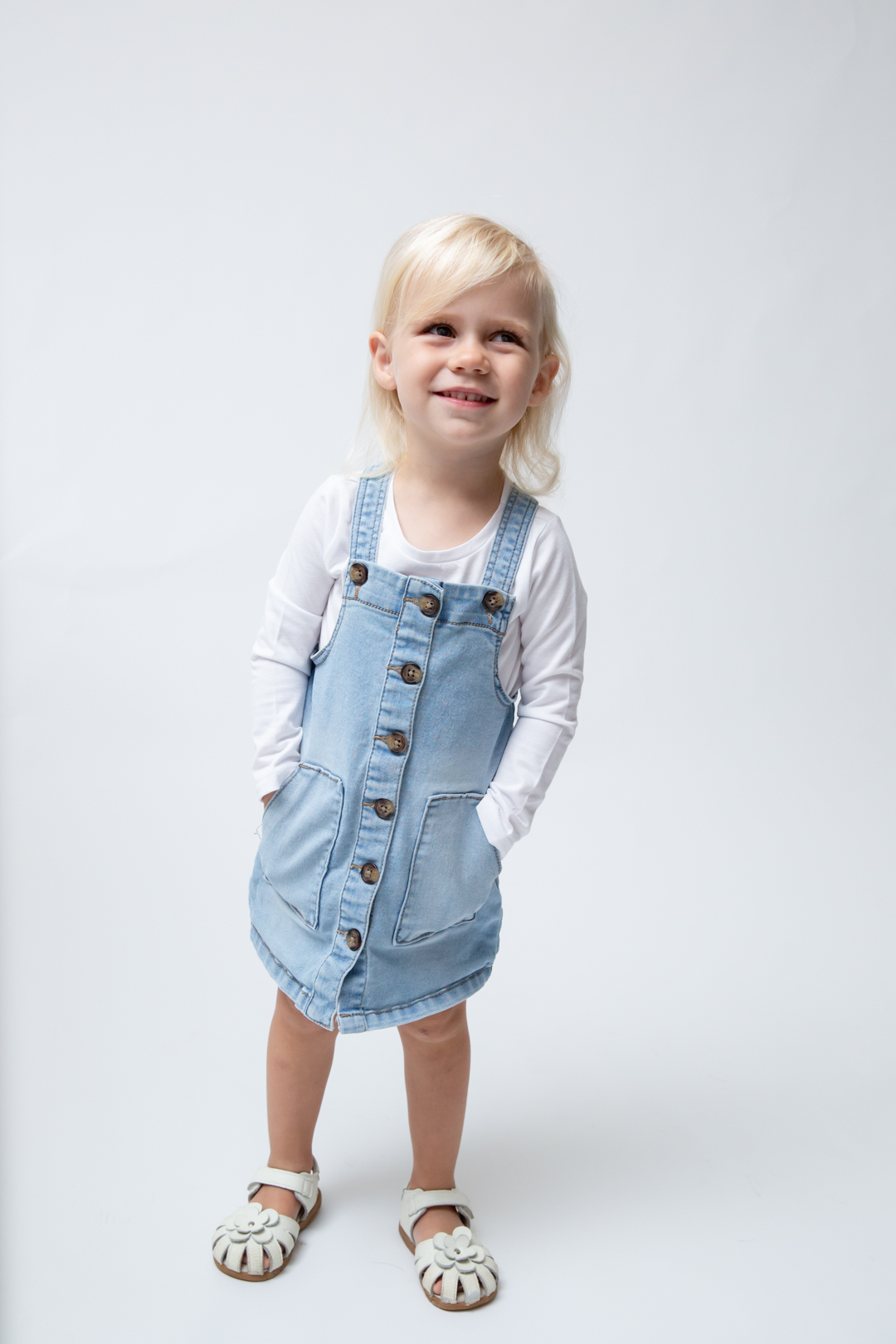 in studio kids portraits wake forest nc. 3 year old girl wearing blue smiling at the camera.