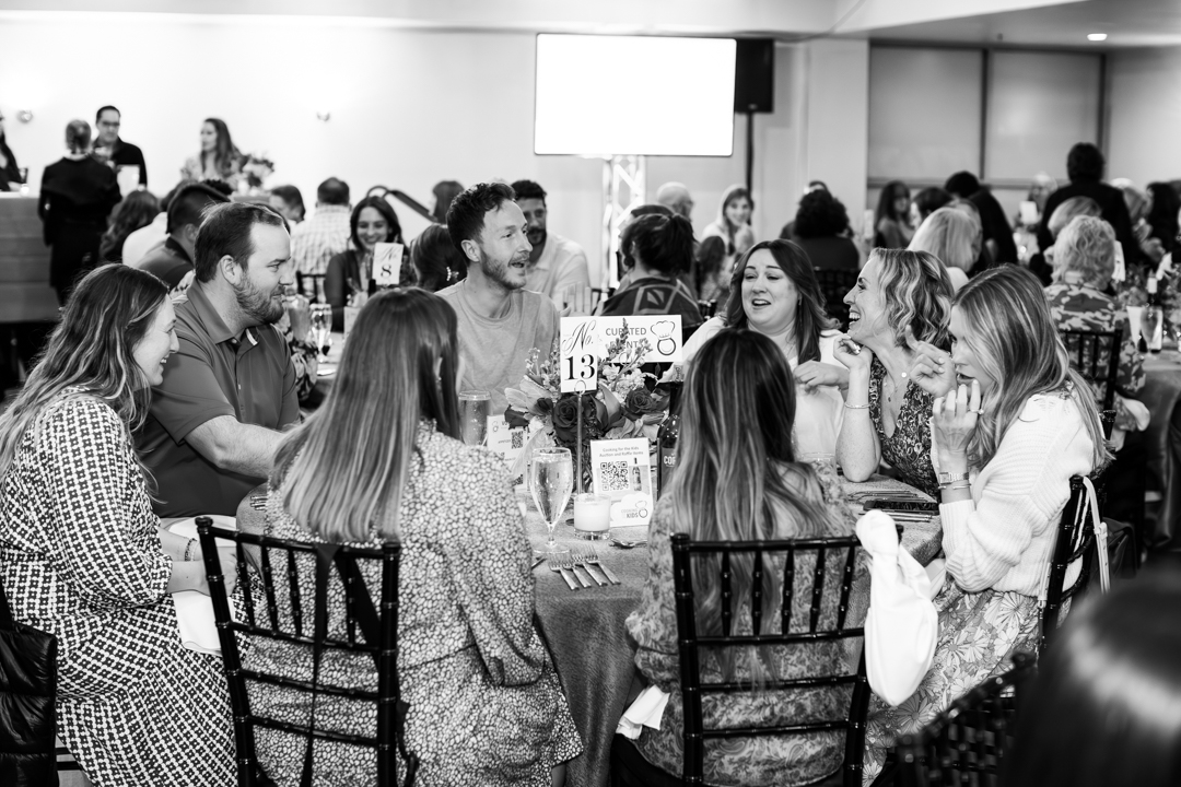 candid photo of guests having lively conversation at cooking for the kids annual charity event supporting children in Raleigh, NC and around the world. Photo captured by Magdalena Stefanek Photography