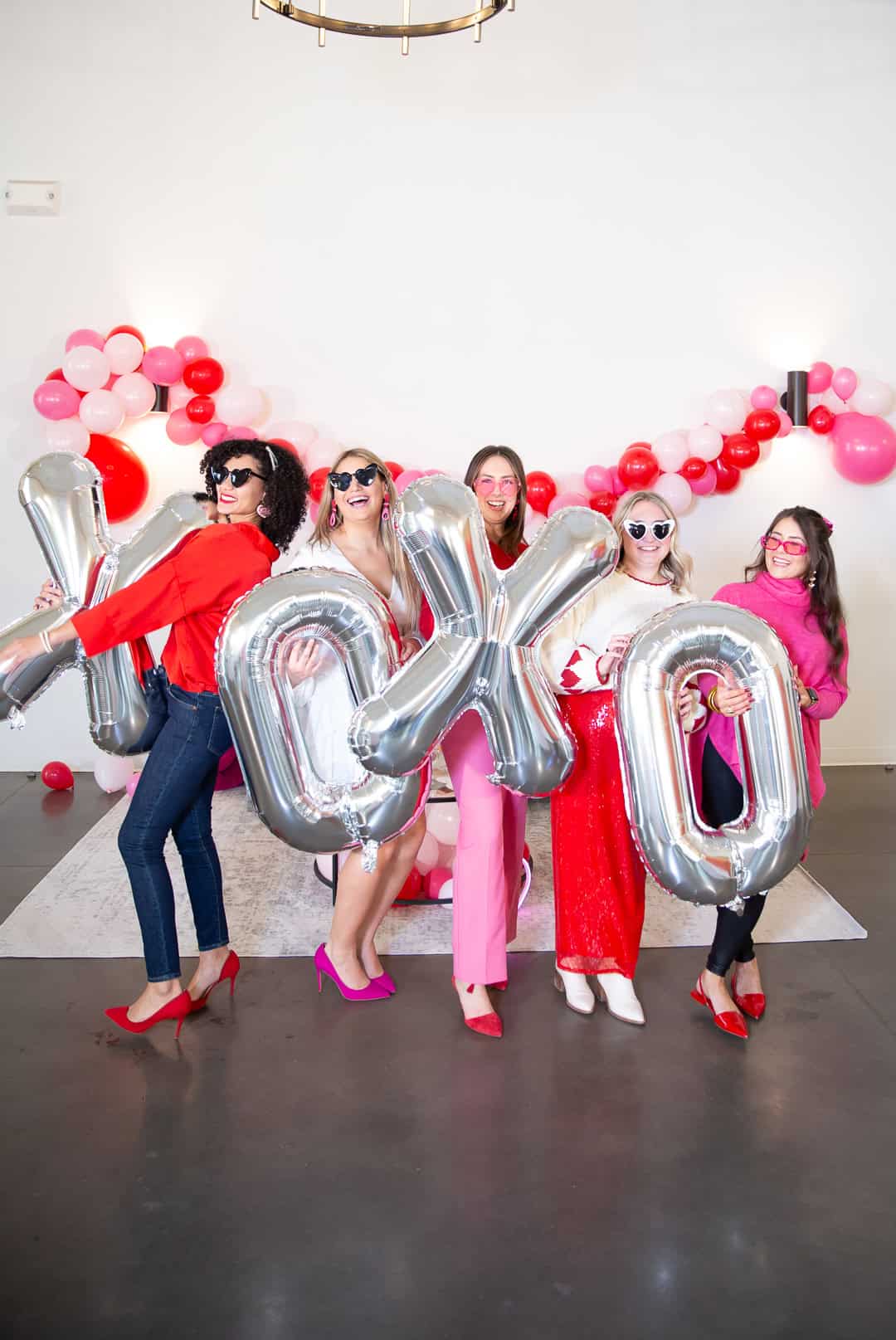 Raleigh event photographer. Adorable ladies wearing pink and red clothes posing for a photo at a Galentine's party at the Maxwell Raleigh, NC.