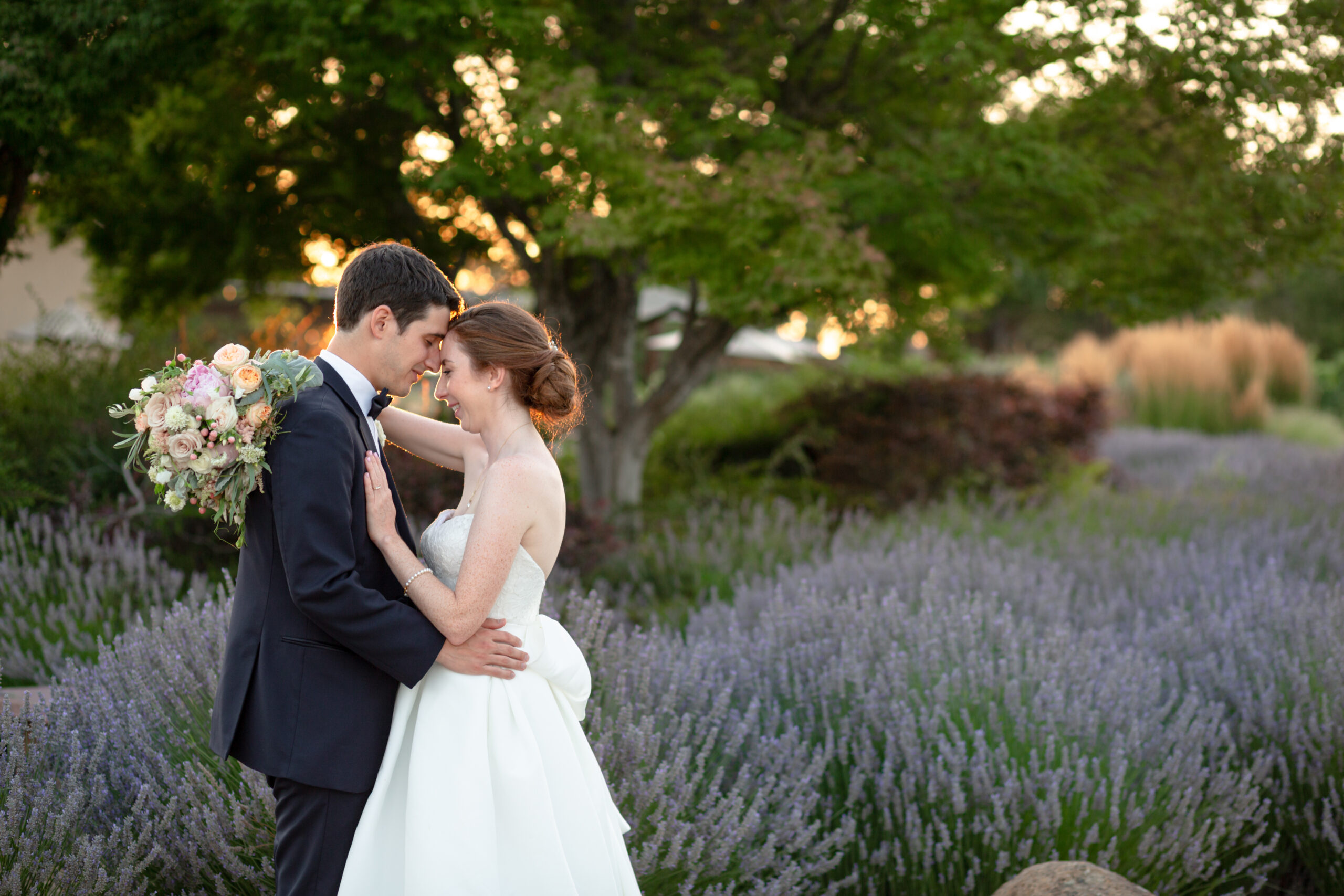 newlyweds posing for a photo among lavender during golden hour portraits captured by Magdalena Stefanek Photography