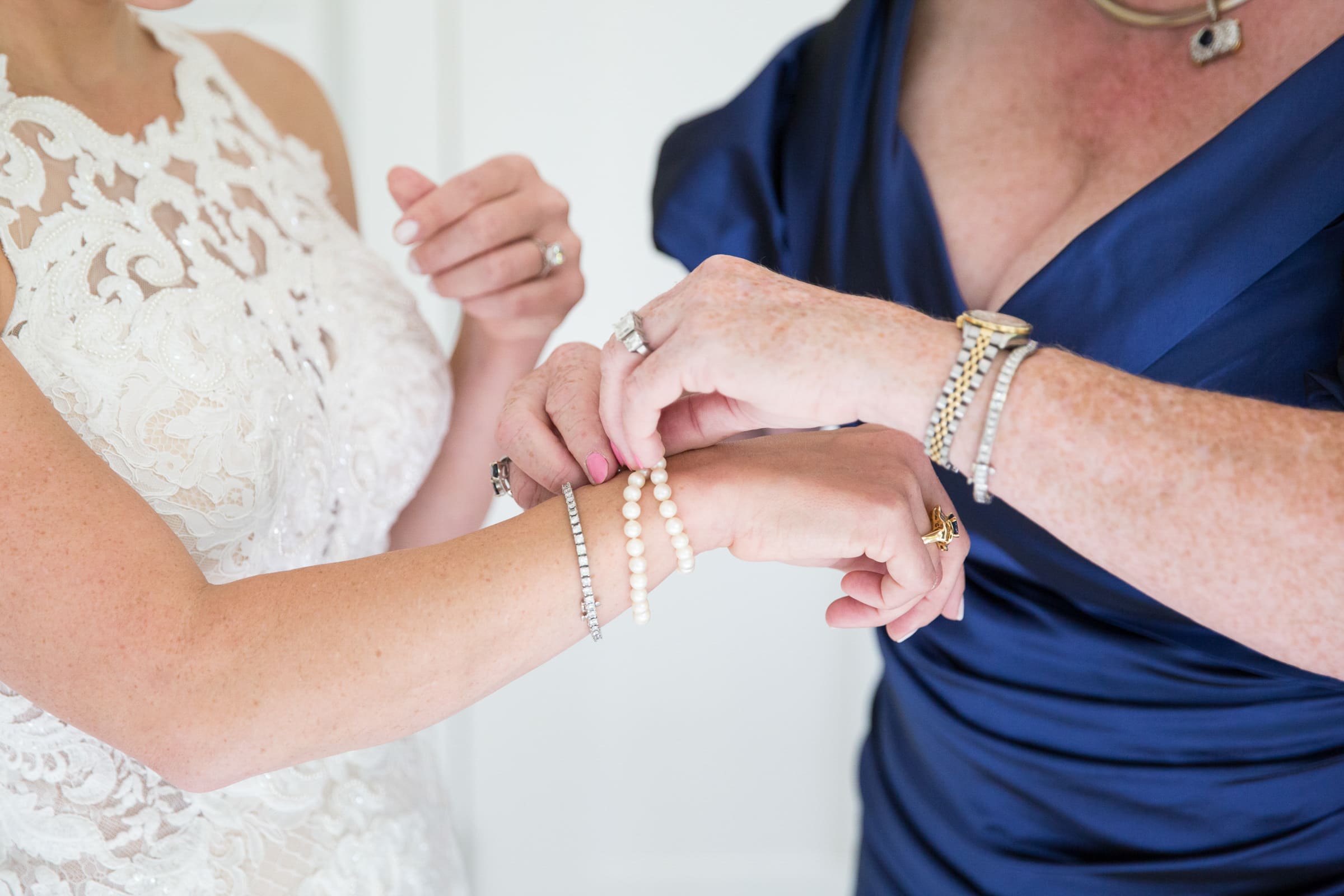 mother of the bride helping the bride with her jewelry. bridal getting ready by Raleigh wedding photographer Magdalena Stefanek Photography