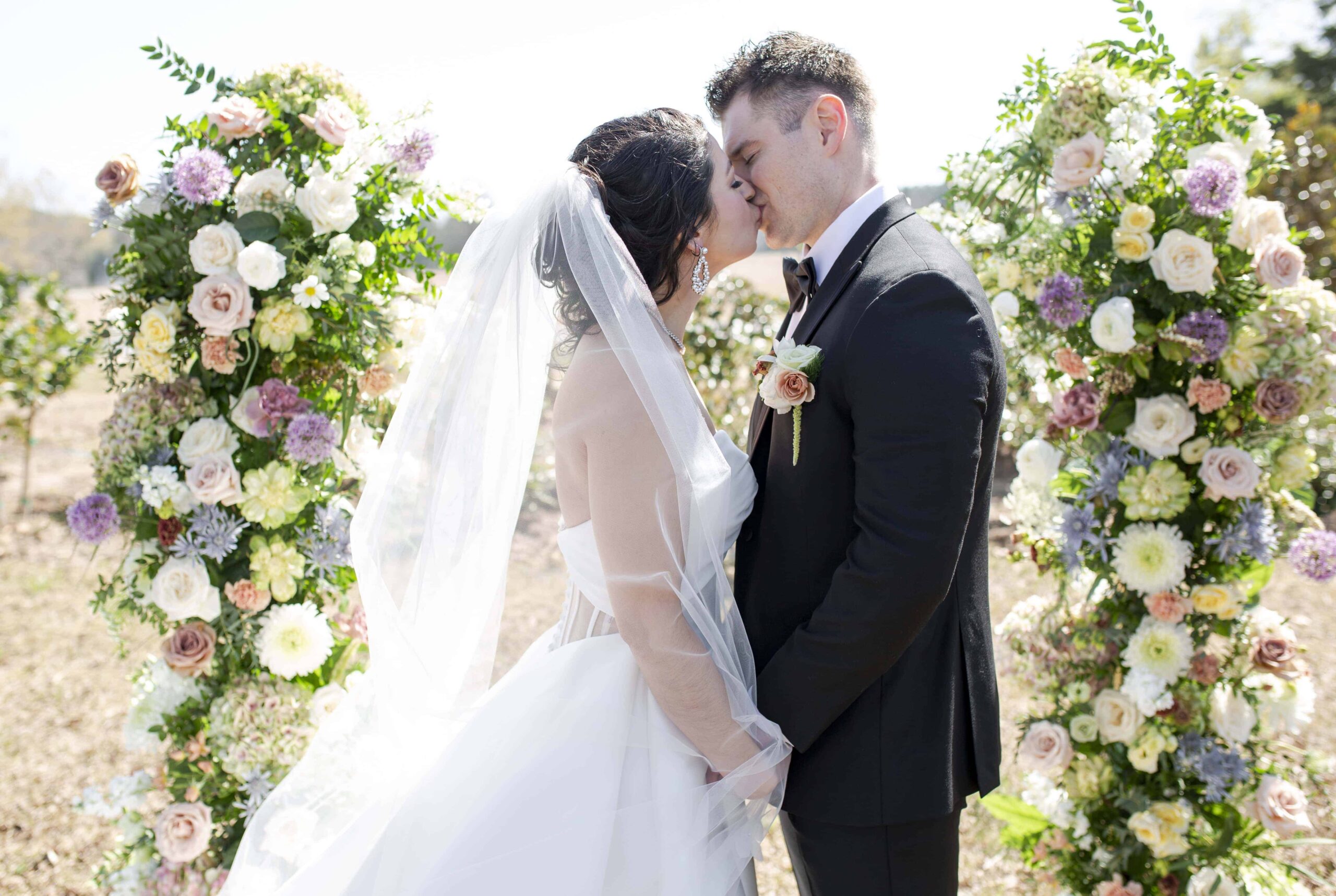 bride and groom firts kiss during spring wedding ceremony at the Landon Estate pecan grove. Landon Estate wedding & elopement photographer.