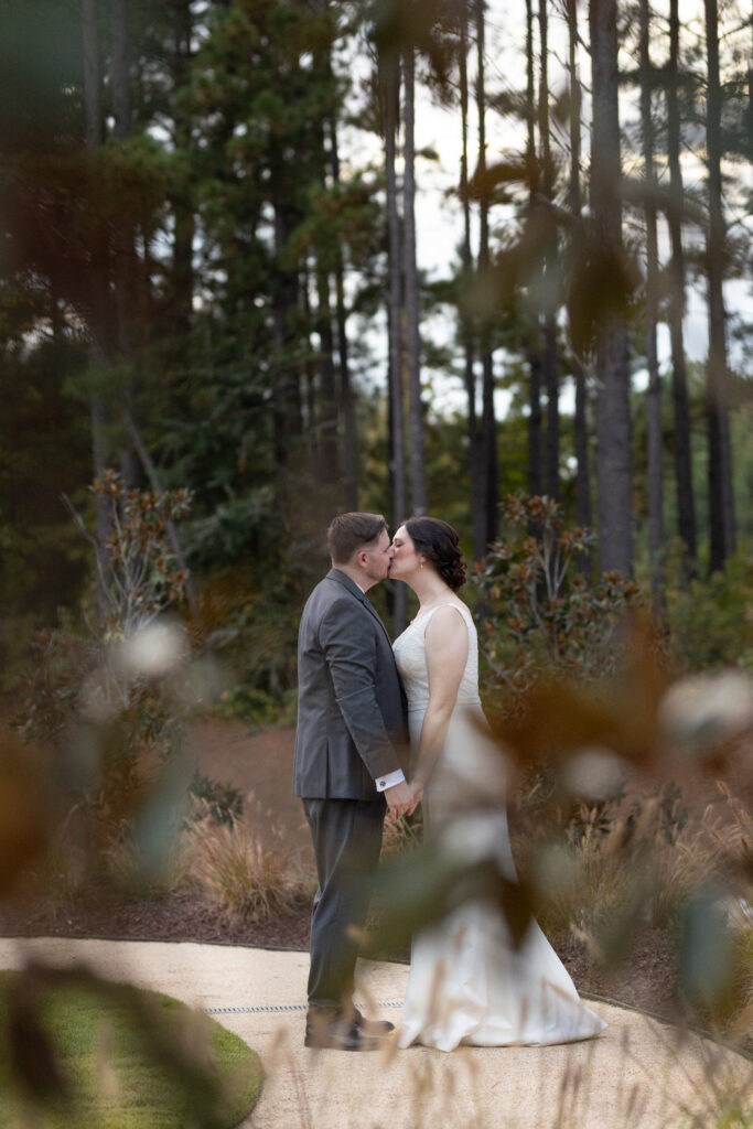 Newlyweds kissing during sunset portraits at the Magnolia Lawn at the Upchurch. 