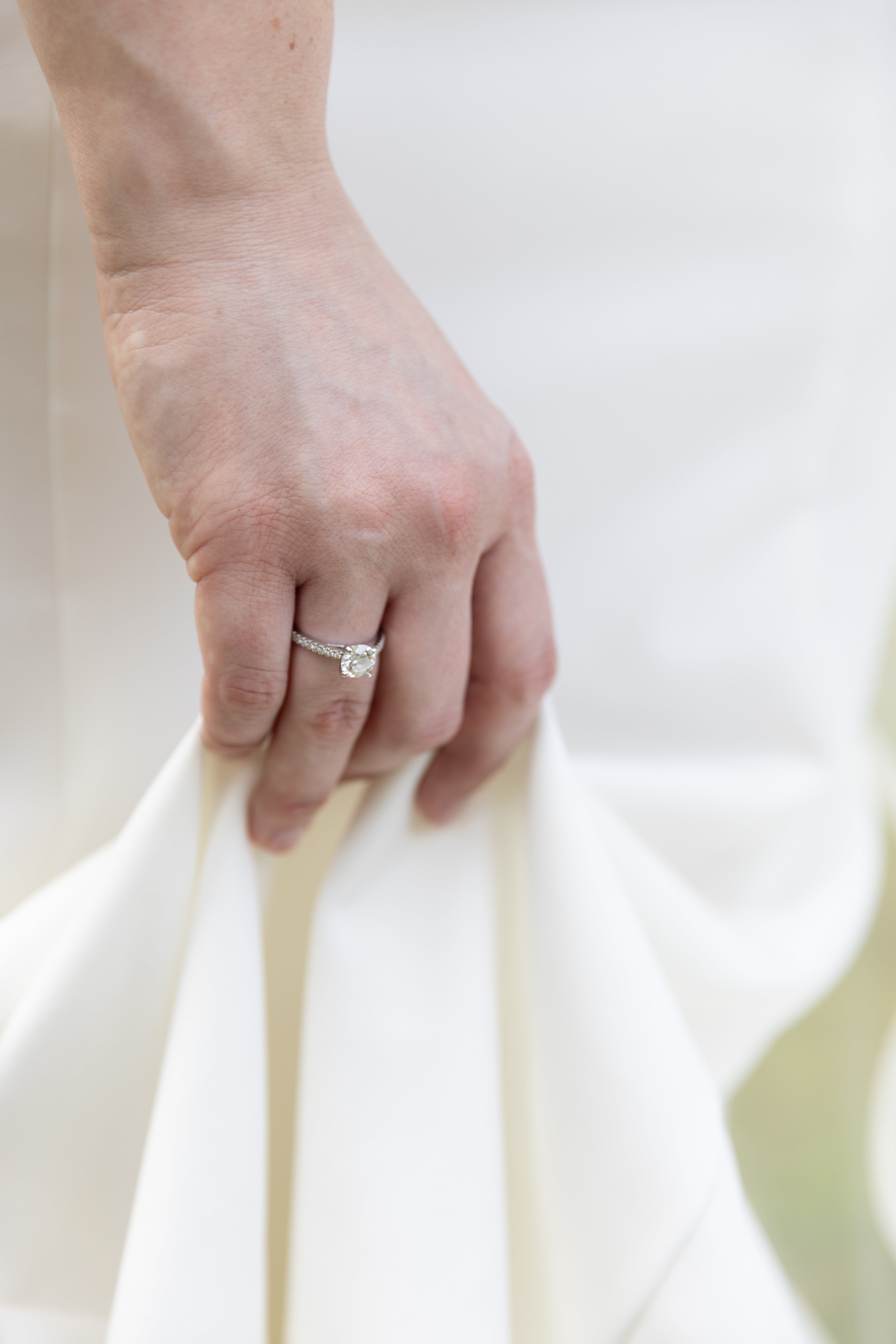 Bride's hand holding her wedding dress