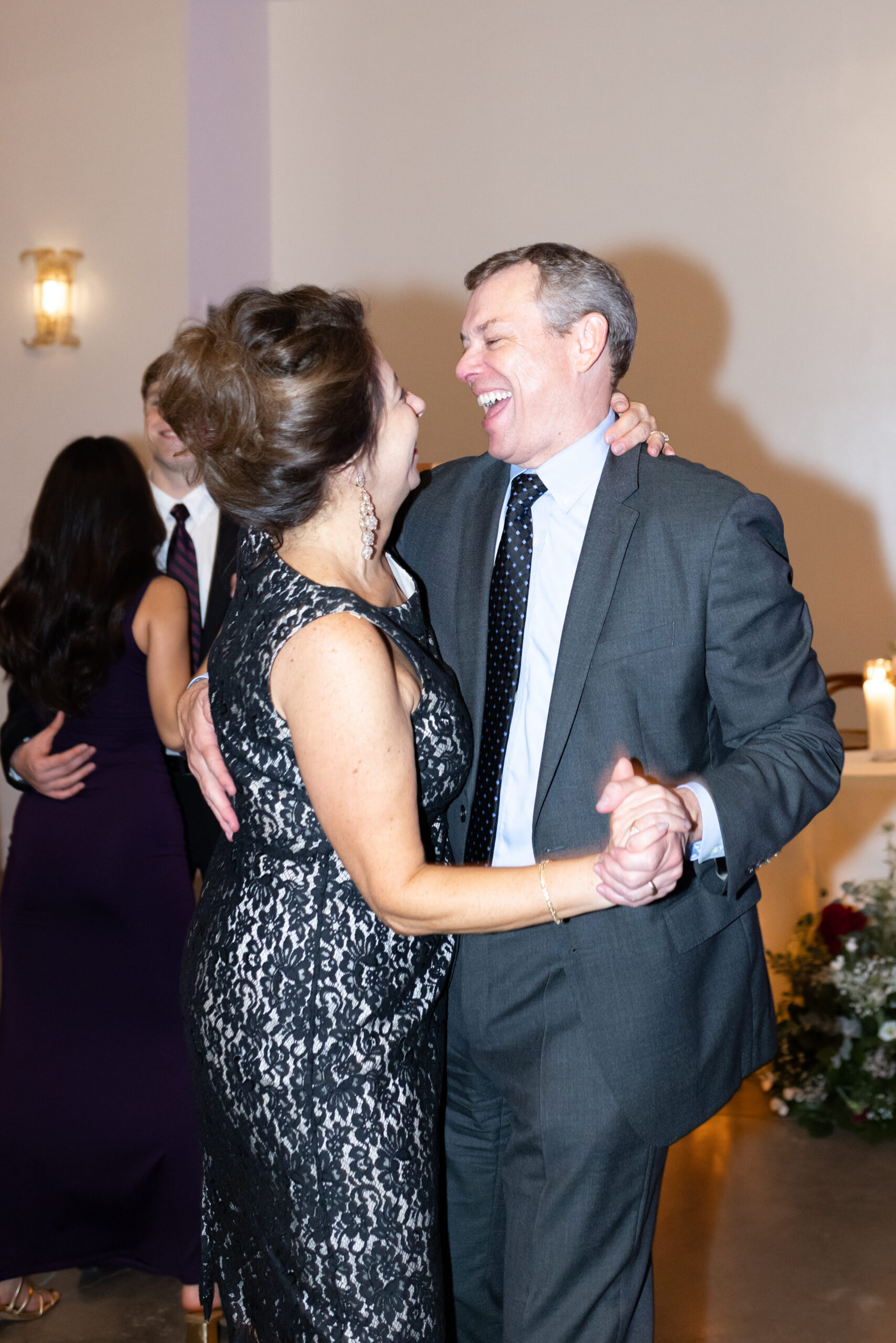 Wedding guests dancing during a wedding reception, having a great time and smiling.
