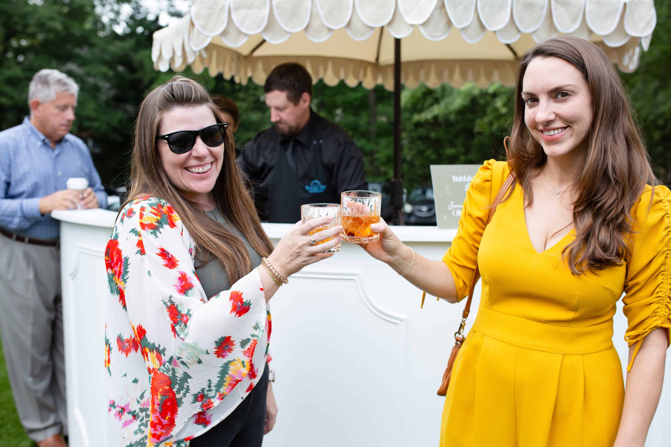 Two women clinging glasses at an event in Raleigh, NC by Magdalena Stefanek Photo