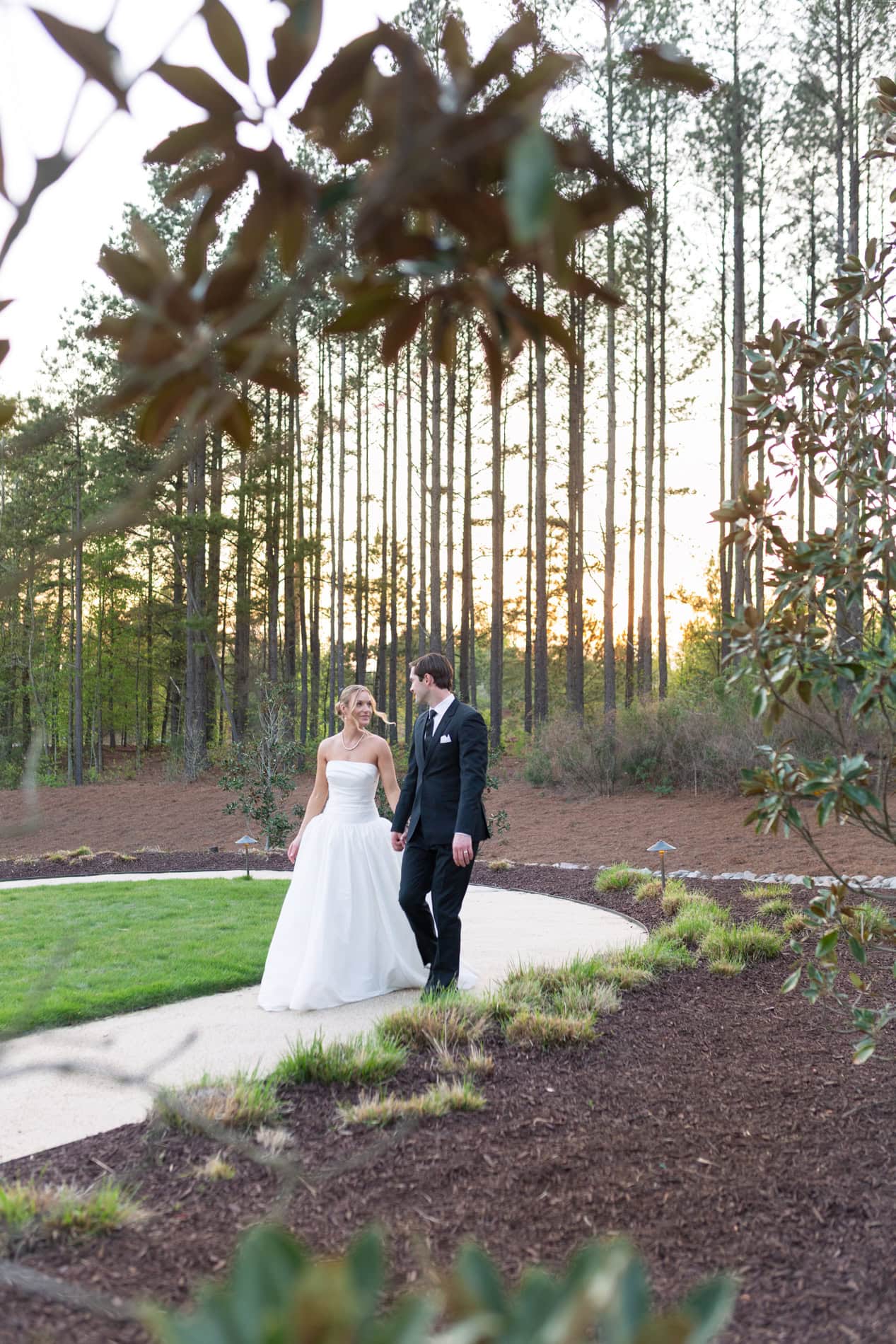 Golden hour portraits of bride and groom strolling the beautiful grounds of the Upchurch venue. Cary wedding photographer.