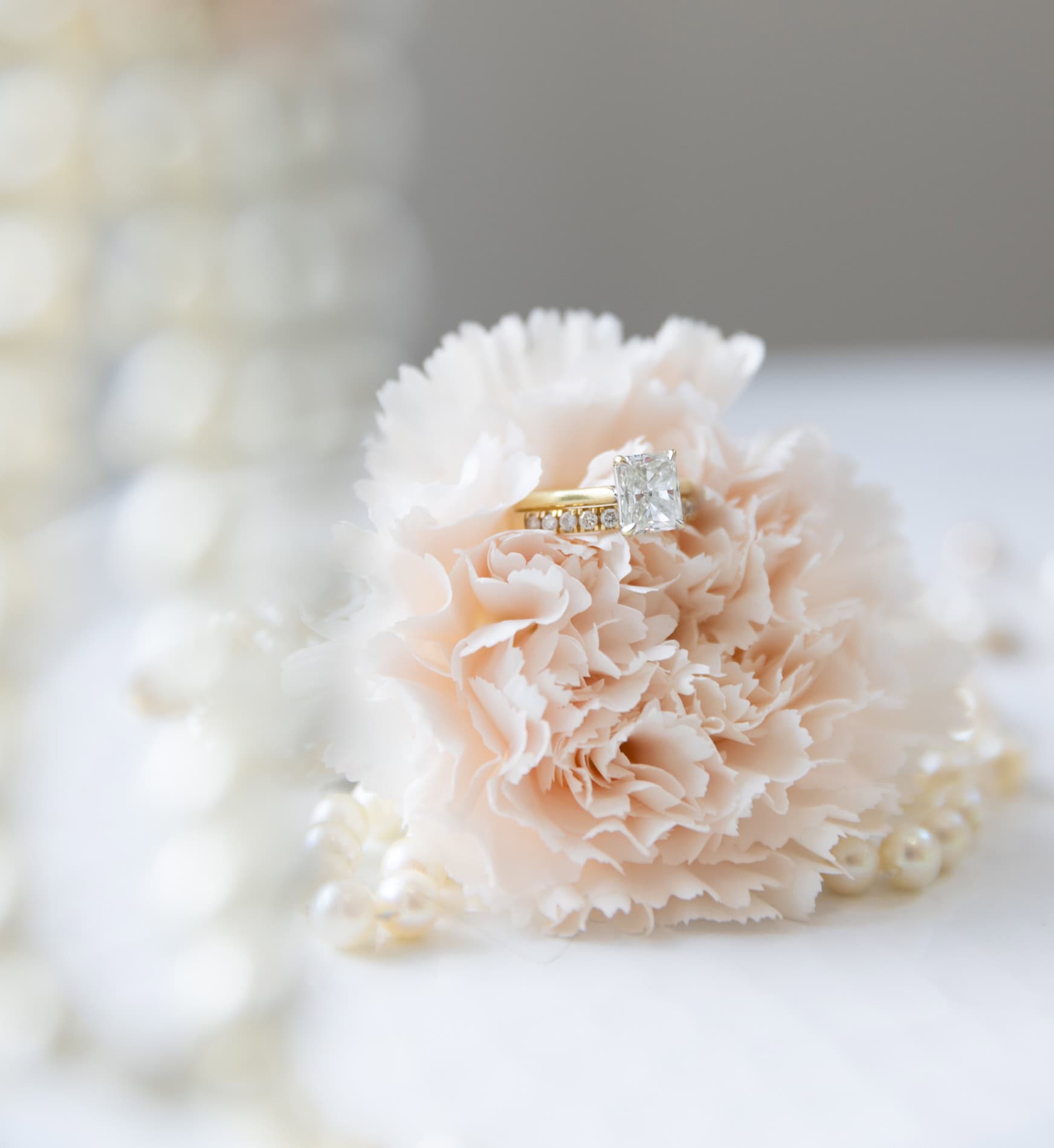 Engagement ring on a blush flower by Magdalena Stefanek.