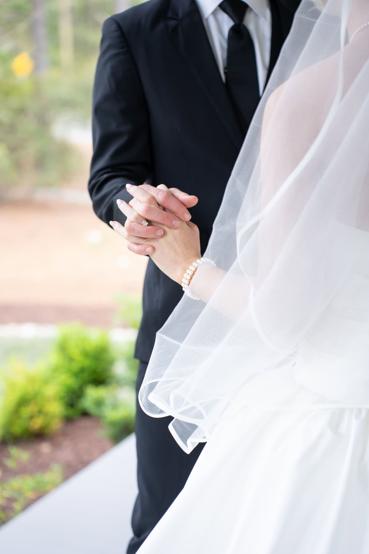 close up of bride and groom holding hands