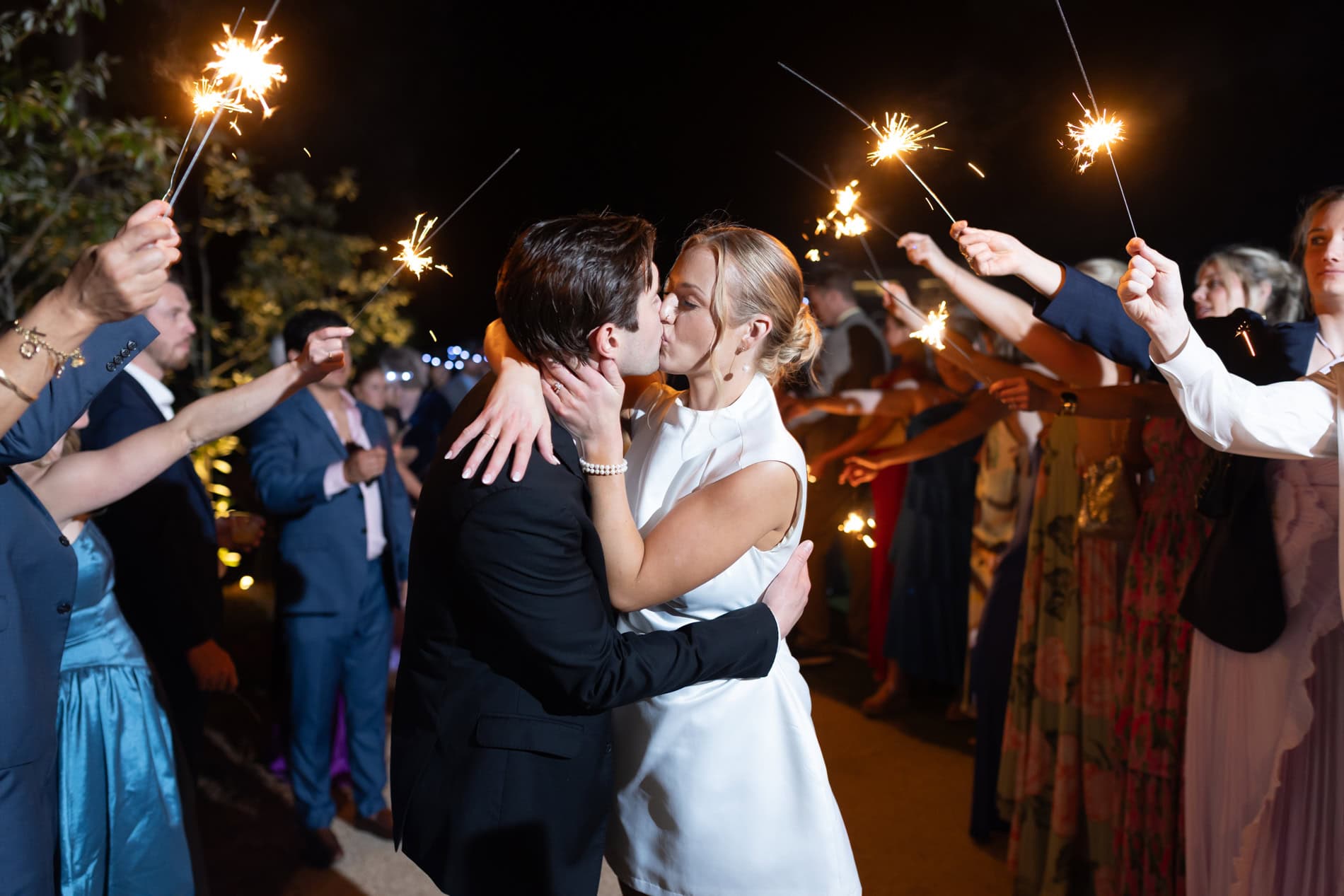 newlyweds kissing during sparkler exit at the upchurch wedding venue in Cary, NC.