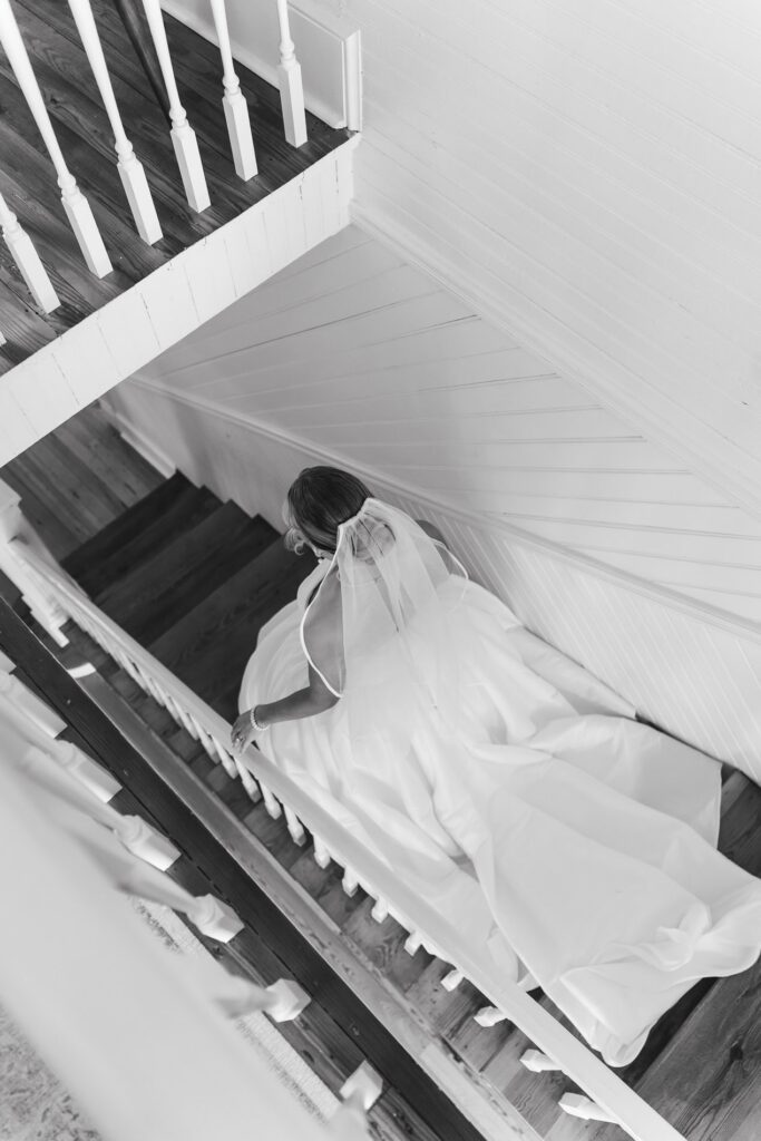 Bride walking down the stairs right before the first look with her fiance. Upchurch.