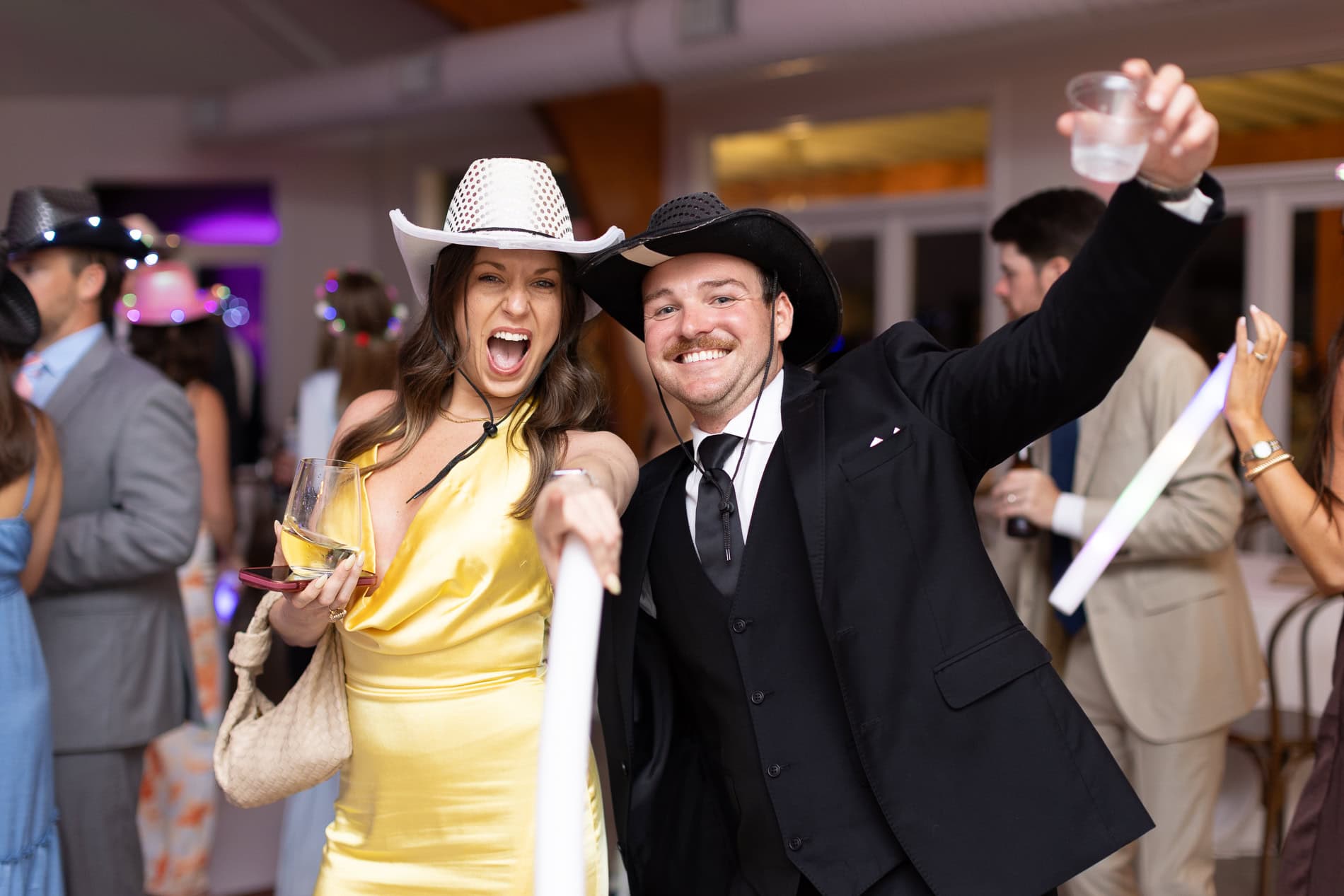wedding guests wearing cowboy hats dancing during wedding reception