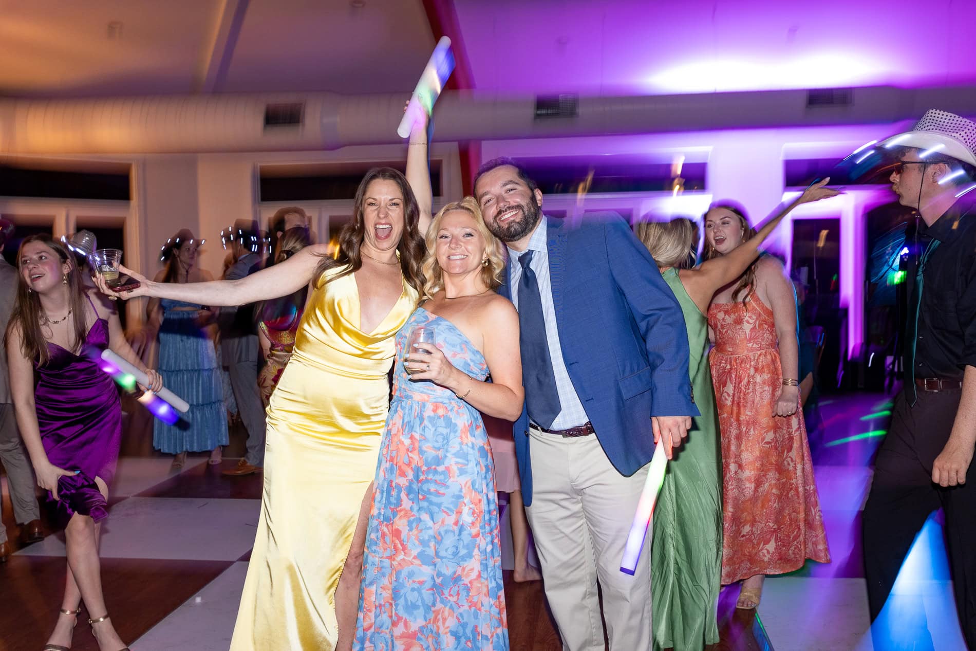 guests posing for a photo on the dancefloor at a wedding