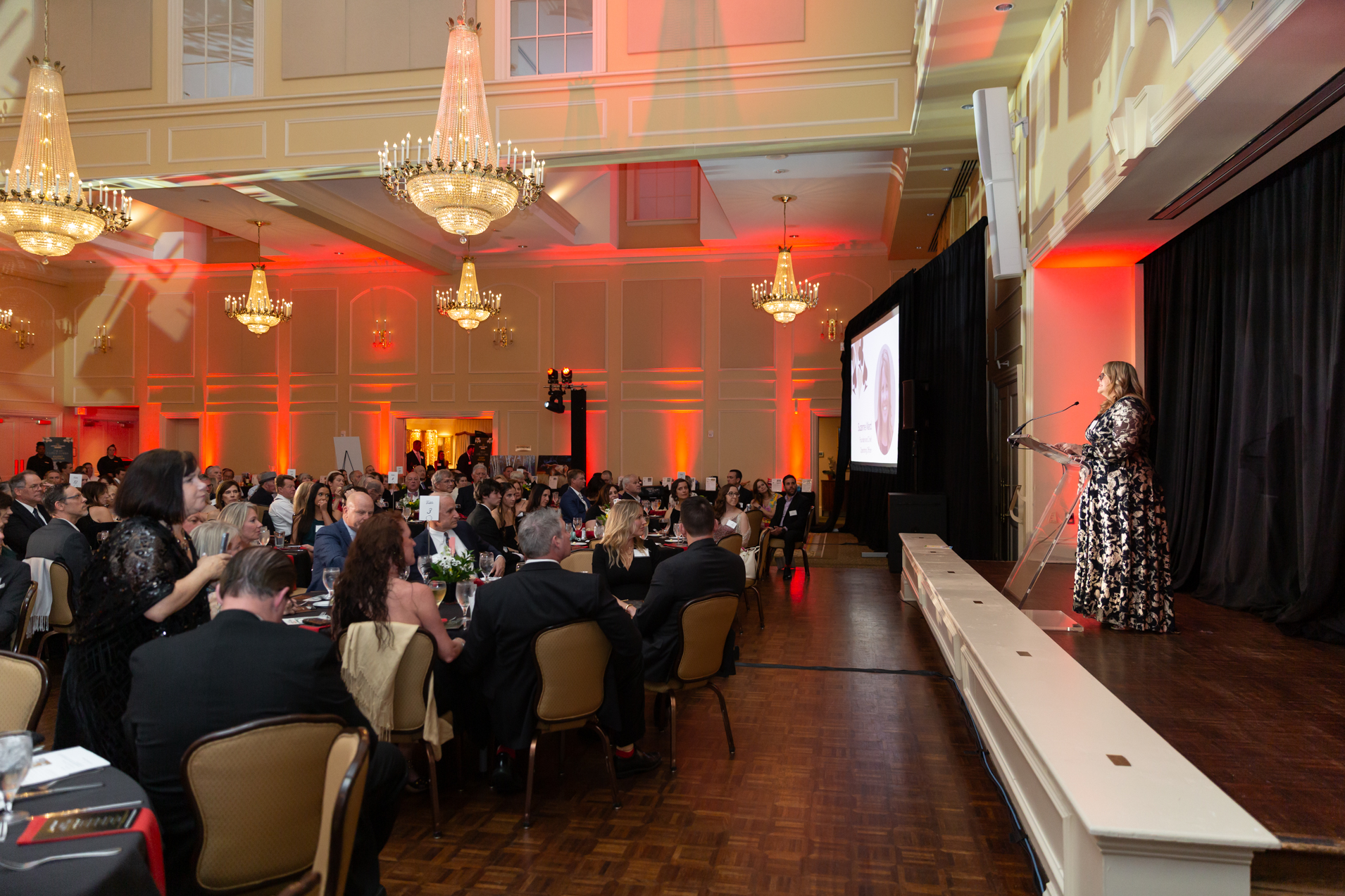 Speaker on the stage of a ballroom at North Ridge Country Club in Raleigh. Corporate Event Photography Raleigh.
