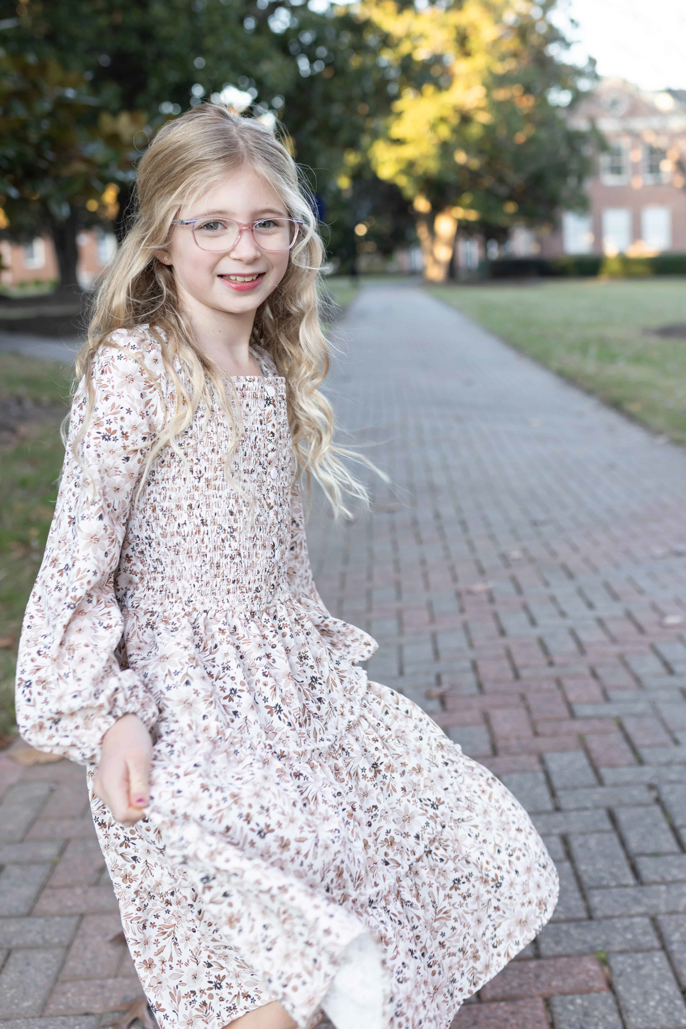 Beautiful girl twirling and holding her floral dress. Wake Forest family photographer.